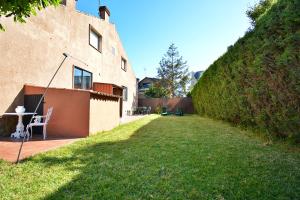 a yard with a table and a chair next to a building at Casa frente al mar en A Illa de Arousa in Isla de Arosa
