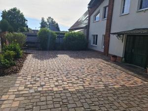 a brick driveway in front of a house at Monteurwohnung SEEBLICK AUSBLICK 16356 Werneuchen bei Berlin in Werneuchen +1 photo