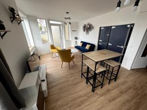 Ouzouer-sur-TrézéeにあるAppartement avec belle vueのリビングルーム(テーブル、椅子付)