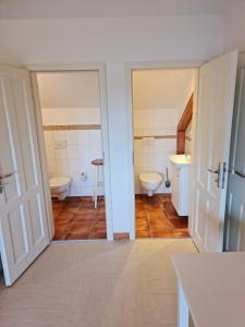 a bathroom with two toilets and a sink at Monteurwohnung SEEBLICK AUSBLICK 16356 Werneuchen bei Berlin in Werneuchen