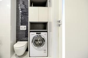 a bathroom with a washing machine and a toilet at About Art Apartments in Wrocław +137 photos