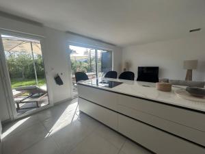 a kitchen with a large island with chairs and a table at Clos d'Alice Villa 3 in Sainte-Maxime