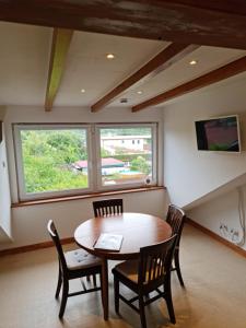 a dining room with a table and chairs and a window at Monteurwohnung SEEBLICK AUSBLICK 16356 Werneuchen bei Berlin in Werneuchen