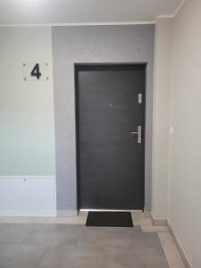 a black door in a room with a tile floor at Apartament Wałowa 4 in Wejherowo
