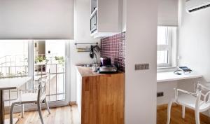 a kitchen with white cabinets and a table and chairs at Nuru Ziya Residences in Istanbul