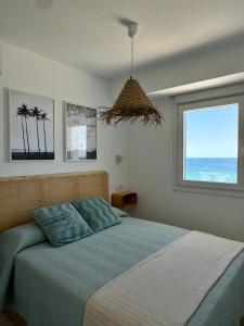 1 dormitorio con 1 cama y vistas al océano en SunnyPalms - Beachfront Penthouse with stunning sea view, en Estepona