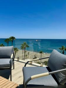 balcón con sillas y vistas a la playa en SunnyPalms - Beachfront Penthouse with stunning sea view, en Estepona