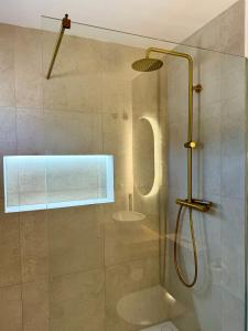 ducha con puerta de cristal junto a un aseo en SunnyPalms - Beachfront Penthouse with stunning sea view, en Estepona