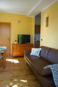 een woonkamer met een bank en een flatscreen-tv bij Ferienwohnung Linde bei Ferienwohnungen May in Plankenfels