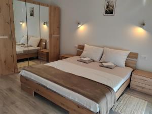 a bedroom with a large bed and a mirror at Apartmani Dubravka in Rab