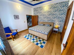 a bedroom with a bed and a blue patterned wall at Comfort & Cozy, Villa in Orchha