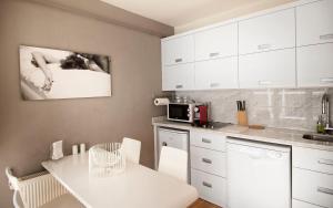 a kitchen with white cabinets and a white table at Nuru Ziya Residences in Istanbul