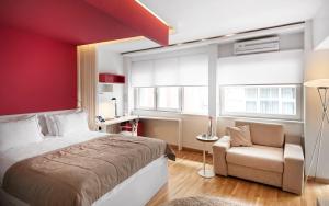 a bedroom with a red wall and a bed and a chair at Nuru Ziya Residences in Istanbul