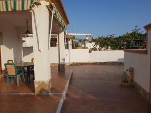 a patio with a table and chairs on a house at Matalascañas MAR in Matalascañas +8 photos