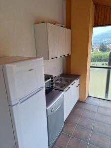 a kitchen with a stove and a white refrigerator at Guest house Adžić in Mojkovac