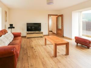 a living room with a couch and a flat screen tv at The Barn, Drumbow Farm in Airdrie