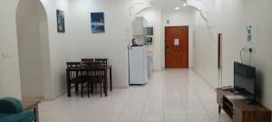 a living room with a table and a refrigerator at شقق الزمرد للشقق المخدومة in Al Khobar