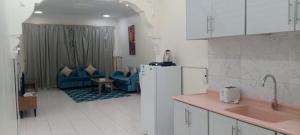 a kitchen with a refrigerator and a living room at شقق الزمرد للشقق المخدومة in Al Khobar +32 photos