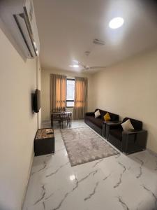 uma sala de estar com um sofá e uma mesa em RED-33 - Gardenia em Salalah