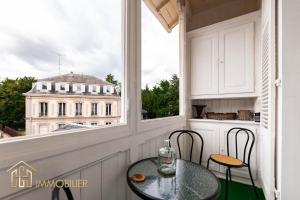 a table and chairs on a balcony with a view of a building at Le Premium - Parking City Center in Colmar