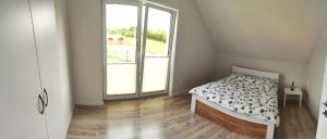 a bedroom with a bed and a large window at Noclegi i ApiTerapia Pszczeli Raj in Huta Szklana