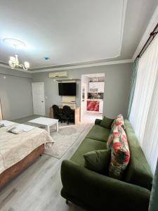 a living room with a green couch and a bed at YALI Suit HOTEL in Trabzon