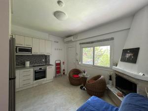 a kitchen with a living room with a fireplace at Karma Apartments in Kalives Poligirou