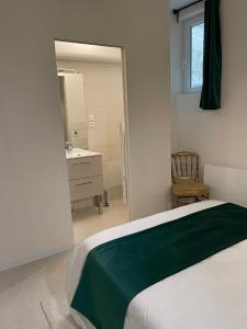 a bedroom with a bed with a green blanket on it at Les Moulins Saint Antoine in Loches