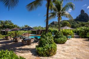 a resort with a swimming pool and palm trees and a patio at Dolphin Hotel in Fernando de Noronha