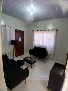 un soggiorno con 2 divani e un divano di FLAT Residencial Caribe a Confresa