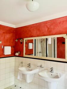 a bathroom with two sinks and red walls at Schloss Karow in Plau am See +54 photos