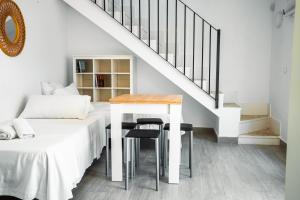 ein Schlafzimmer mit einem Bett, einem Tisch und einer Treppe in der Unterkunft Escuela Village in Marbella + 35 Fotos