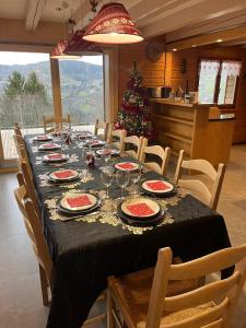ein Esstisch mit einem Weihnachtsbaum im Hintergrund in der Unterkunft Chalet Les Bouvreuils La Bresse Haute Vosges in La Bresse
