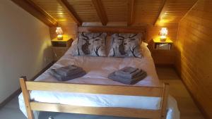 ein Bett in einem Zimmer mit zwei Handtüchern darauf in der Unterkunft Chalet Les Bouvreuils La Bresse Haute Vosges in La Bresse