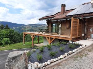 ein Haus mit einer Terrasse mit Aussicht in der Unterkunft Chalet Les Bouvreuils La Bresse Haute Vosges in La Bresse