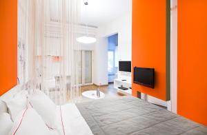 a bedroom with orange walls and a bed and a tv at Nuru Ziya Residences in Istanbul