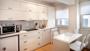 a white kitchen with a table and a microwave at Nuru Ziya Residences in Istanbul