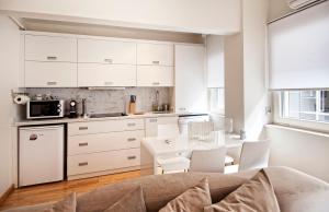 a kitchen with white cabinets and a table and chairs at Nuru Ziya Residences in Istanbul