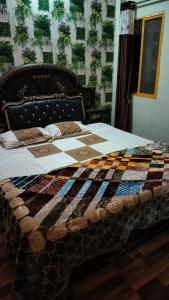 een bed met een quilt erop in een kamer bij Pooja home stay in Ujjain