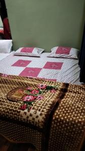 een bed met een roze en wit dekbed met bloemen erop bij Pooja home stay in Ujjain