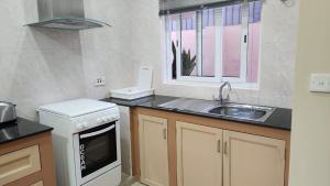 a kitchen with a sink and a stove and a window at Green self-catering Apartment in Beau Vallon