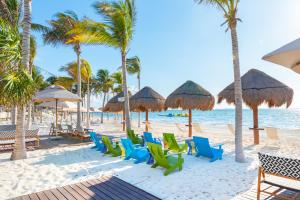 a beach with chairs and umbrellas and the ocean at Garza Blanca Resort & Spa Cancun in Canc&uacute;n