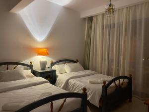 two beds in a hotel room with a window at Villa at Santa Monica Next to Almaza Bay in Marsa Matruh