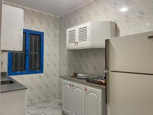 a kitchen with a refrigerator and white cabinets at Villa at Santa Monica Next to Almaza Bay in Marsa Matruh
