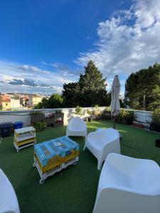 Un patio con muebles blancos y una sombrilla. en B&B Il Glicine Pescara centro, en Pescara