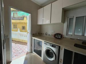a kitchen with a washing machine and a window at Apartamento Fnideq, Familia, Bienestar y mercado in Riffiene