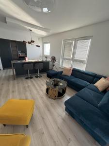 a living room with a blue couch and a table at Apartament Relax in Gdańsk