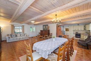 a dining room with a table and a kitchen at Dobilyne Homestead in Gražiškiai