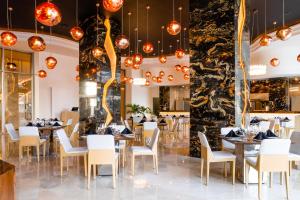 une salle à manger avec tables, chaises et lustres dans l'établissement Garza Blanca Resort & Spa Cancun, à Cancún