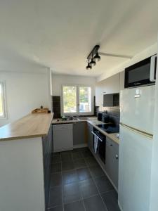 ラ・シオタにあるHaut de villa avec vue mer et terrasseの白い冷蔵庫とカウンタートップのあるキッチン